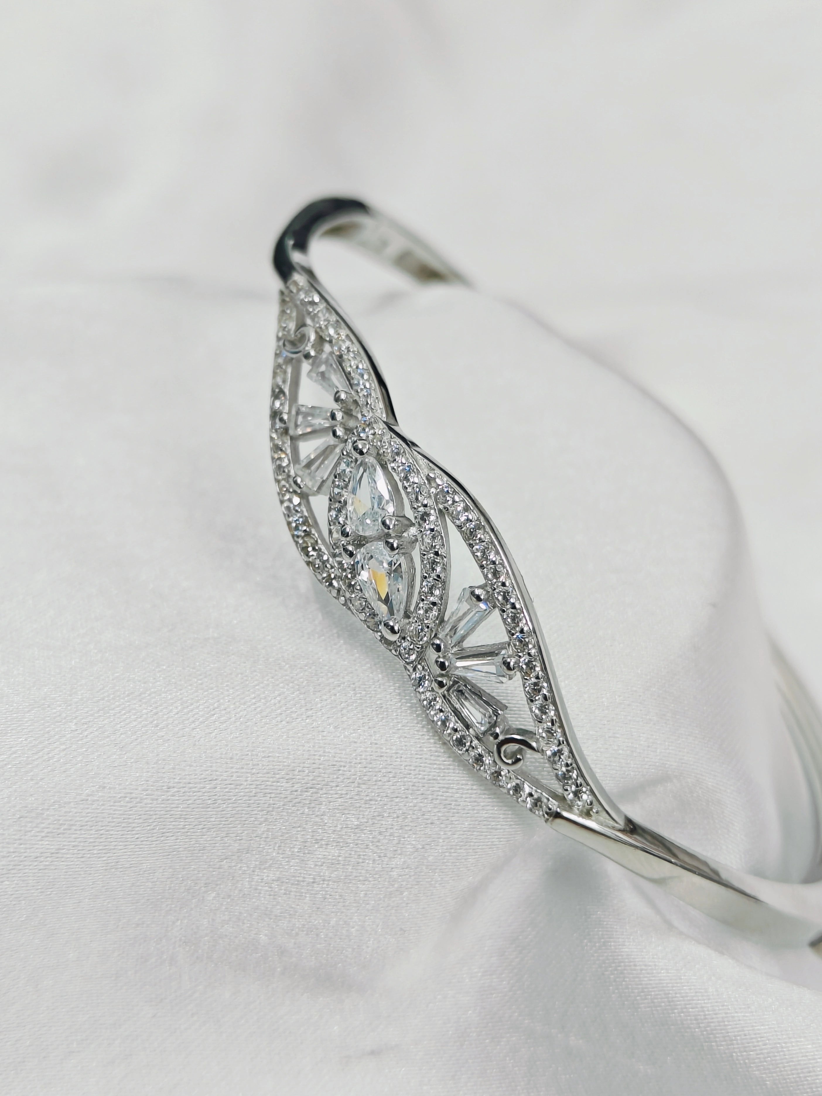 Silver bracelet with diamond accents on a white background